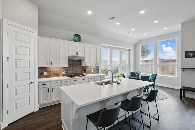 4121 Crossroads Ct, Oak Point, TX 75068 - kitchen featuring dark wood-type flooring, a center island with sink, decorative backsplash, white cabinetry, and recessed lighting