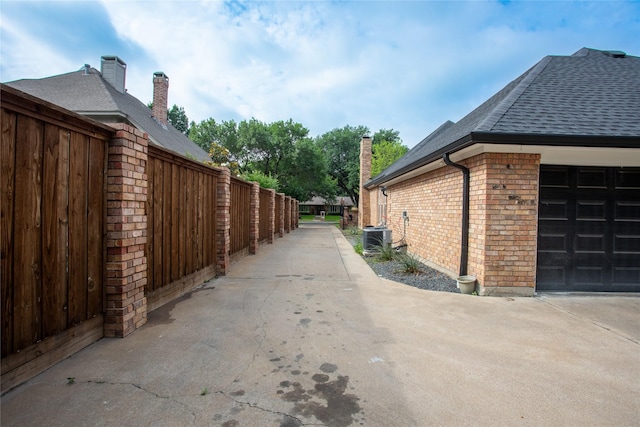 509 Farine Dr, Irving, TX 75062 - view of side of home featuring roof with shingles, central AC, fence, and brick siding