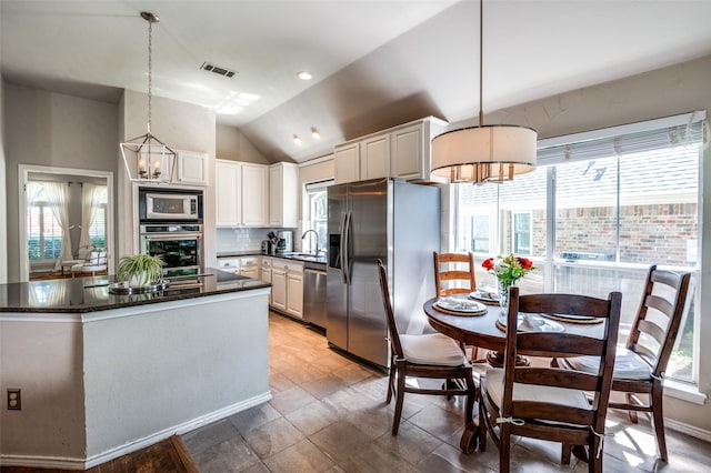 1433 Rogers Ct, Allen, TX 75013 - kitchen with stainless steel appliances, a sink, a kitchen island, plenty of natural light, and vaulted ceiling