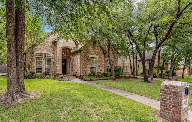 view of front of property featuring a front lawn and brick siding