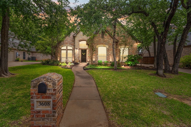view of front of house with a yard and brick siding