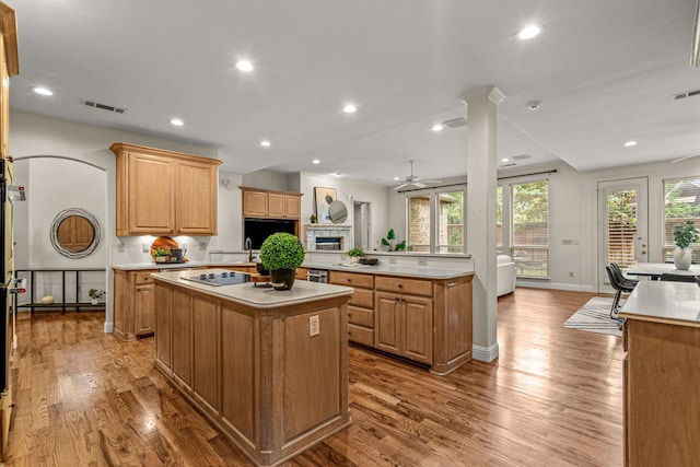 kitchen featuring a kitchen island, open floor plan, light countertops, light wood-type flooring, and recessed lighting