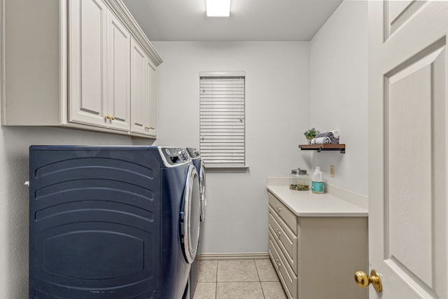 clothes washing area featuring cabinet space, independent washer and dryer, light tile patterned flooring, and baseboards