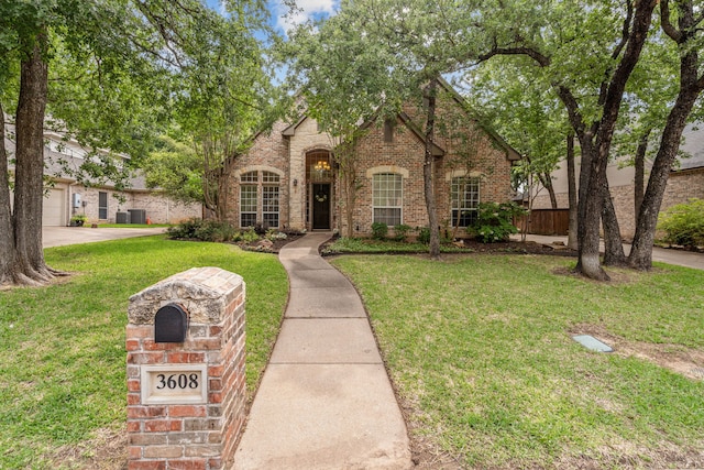 view of front of house with brick siding and a front lawn