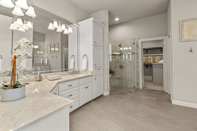 full bath with a stall shower, a chandelier, vanity, baseboards, and recessed lighting