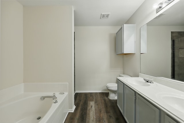 2324 Southway, Denton, TX 76207 - full bathroom featuring wood finished floors, a garden tub, double vanity, toilet, and baseboards