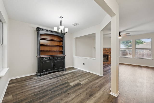 2324 Southway, Denton, TX 76207 - unfurnished living room featuring a chandelier, dark wood-style flooring, a brick fireplace, a ceiling fan, and baseboards