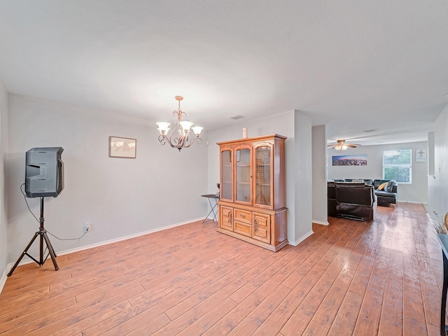 9228 Cheswick Dr, Fort Worth, TX 76123 - empty room with a chandelier, light wood finished floors, a ceiling fan, and baseboards