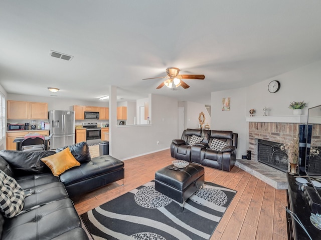 9228 Cheswick Dr, Fort Worth, TX 76123 - living area with light wood-style floors, ceiling fan, baseboards, and a fireplace