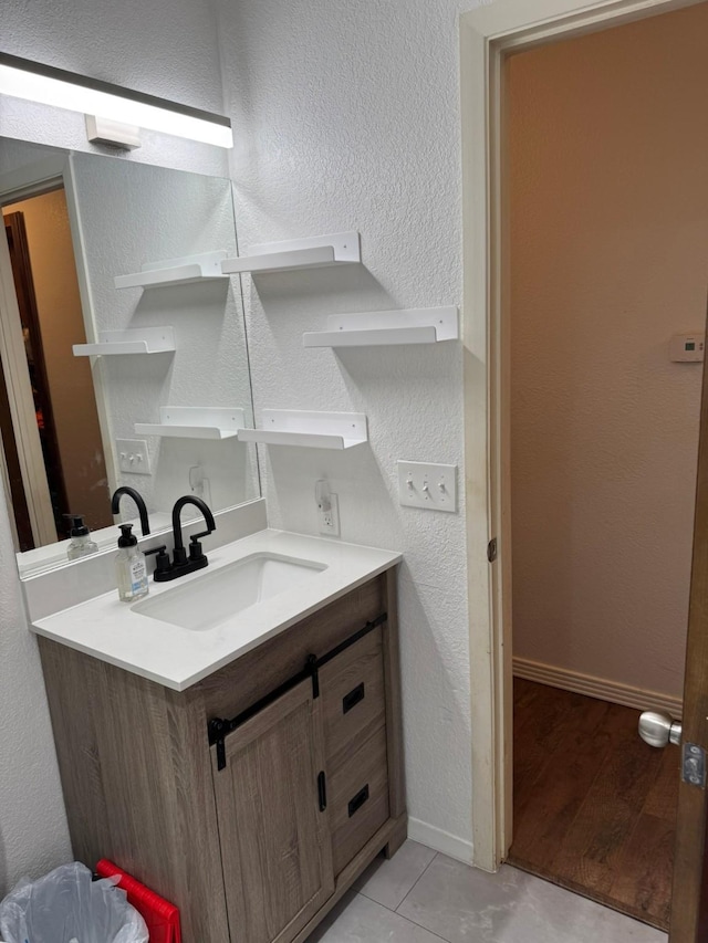 419 Travis St, Ranger, TX 76470 - bathroom with vanity, a textured wall, baseboards, and tile patterned flooring