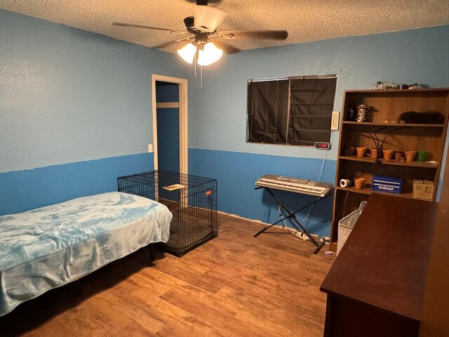 419 Travis St, Ranger, TX 76470 - bedroom featuring a textured ceiling, wood finished floors, and ceiling fan