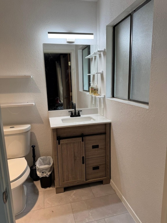 419 Travis St, Ranger, TX 76470 - bathroom with tile patterned floors, vanity, toilet, and a textured wall