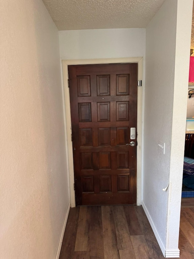 419 Travis St, Ranger, TX 76470 - hallway featuring wood finished floors, baseboards, and a textured ceiling