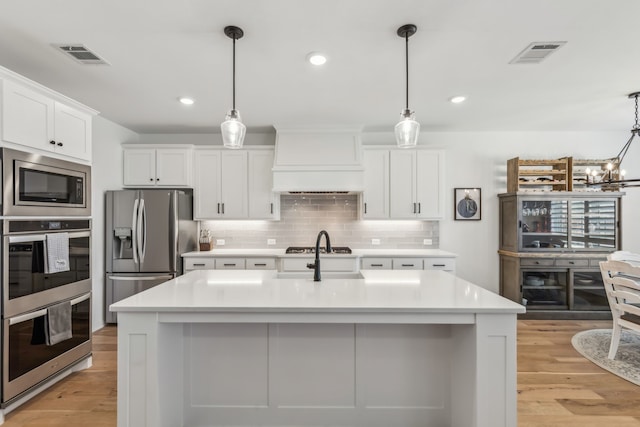 2171 Cloverfern Way, Haslet, TX 76052 - kitchen featuring appliances with stainless steel finishes, custom exhaust hood, light countertops, white cabinetry, and backsplash