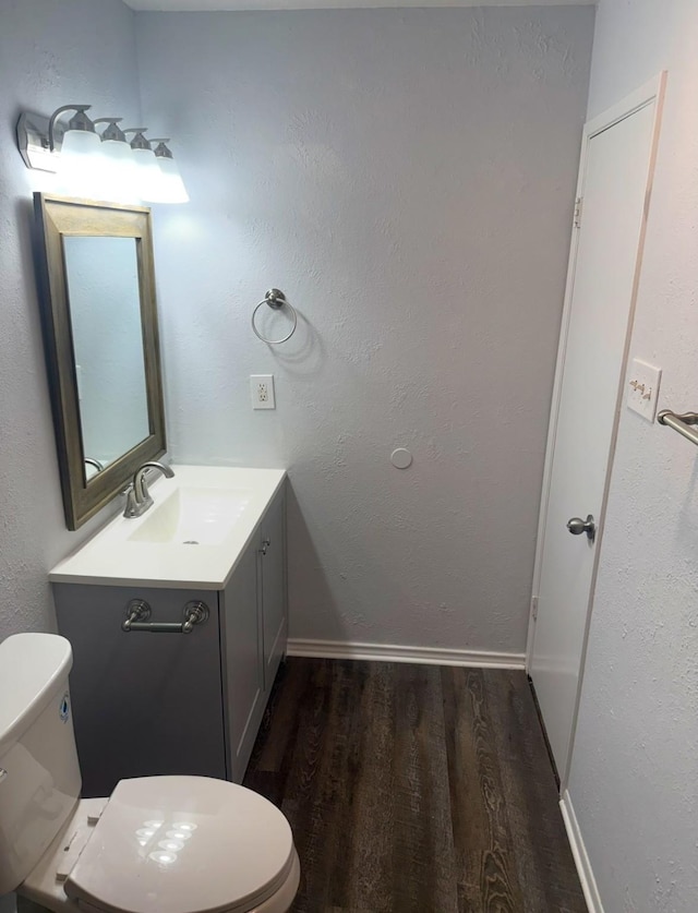 553 Oldbridge Dr, Allen, TX 75002 - half bath featuring wood finished floors, toilet, vanity, and baseboards