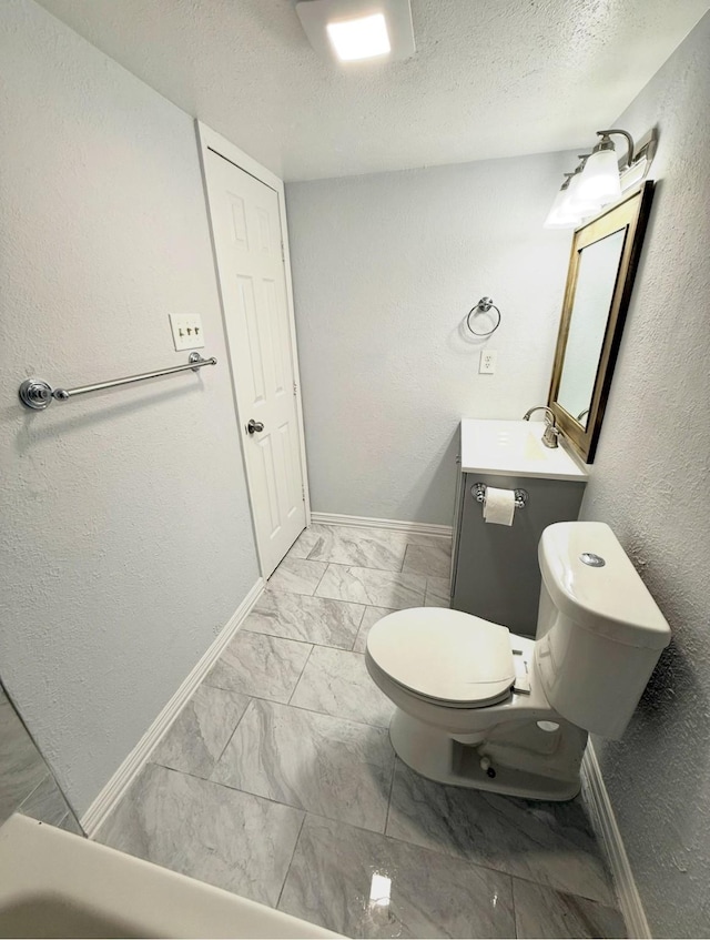 553 Oldbridge Dr, Allen, TX 75002 - bathroom with marble look tiles, baseboards, a textured ceiling, vanity, and a textured wall