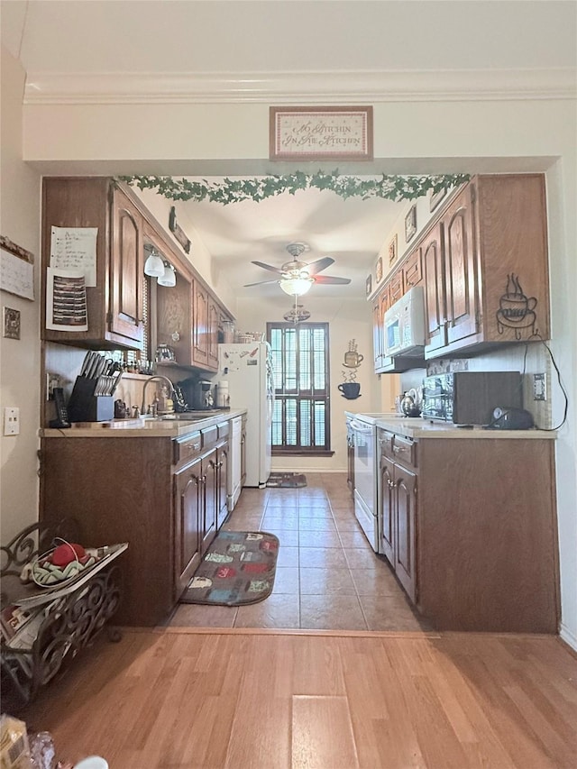 850 Oakbluff Dr, Lancaster, TX 75146 - kitchen with white appliances, a sink, ceiling fan, light wood finished floors, and dark brown cabinetry