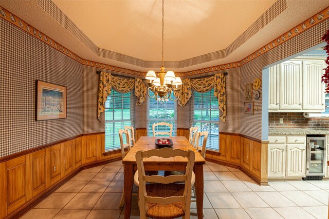 521 Crestridge Rd, Heath, TX 75032 - dining room featuring beverage cooler, a wainscoted wall, a chandelier, light tile patterned floors, and ornamental molding