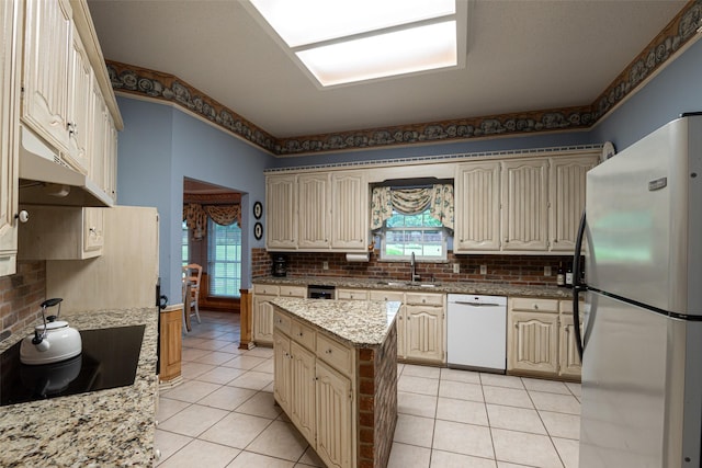 521 Crestridge Rd, Heath, TX 75032 - kitchen with freestanding refrigerator, dishwasher, cream cabinetry, light tile patterned floors, and decorative backsplash