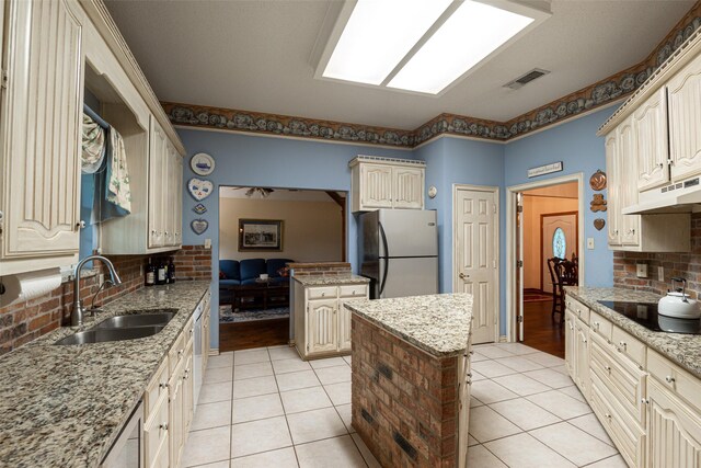 521 Crestridge Rd, Heath, TX 75032 - kitchen featuring freestanding refrigerator, black electric stovetop, under cabinet range hood, cream cabinets, and a sink