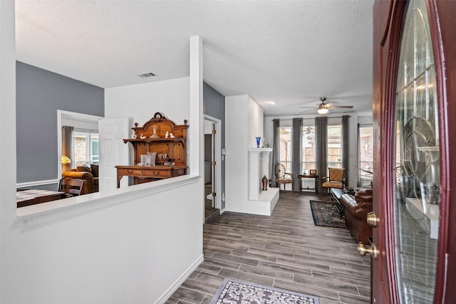 6706 Trumpet Dr, Rowlett, TX 75089 - hall with healthy amount of natural light, baseboards, a textured ceiling, and wood finished floors