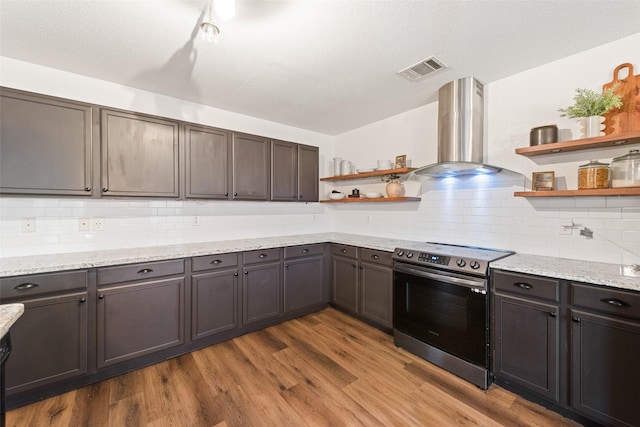 7536 Brentwood Stair Rd, Fort Worth, TX 76112 - kitchen featuring open shelves, stainless steel electric stove, wall chimney exhaust hood, and decorative backsplash