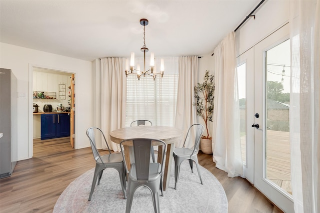 7536 Brentwood Stair Rd, Fort Worth, TX 76112 - dining area featuring a chandelier and light wood-style flooring