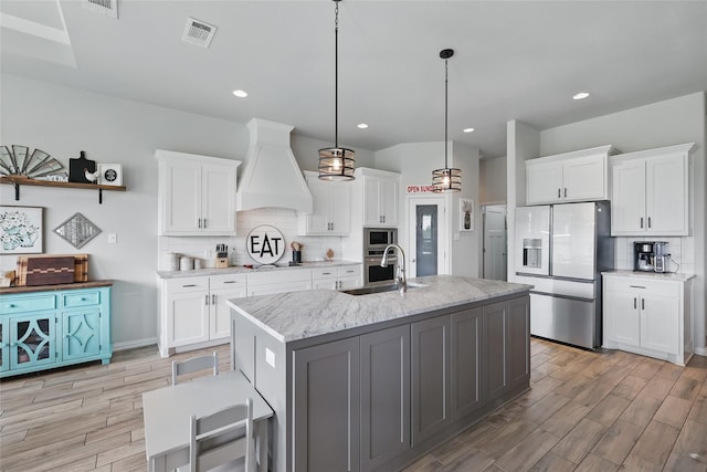 115 Lavender Ln, Springtown, TX 76082 - kitchen featuring stainless steel appliances, custom exhaust hood, light wood-type flooring, backsplash, and recessed lighting