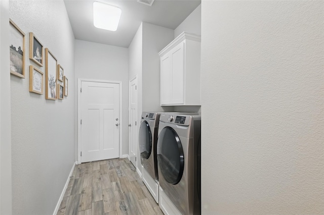 115 Lavender Ln, Springtown, TX 76082 - laundry area featuring separate washer and dryer, light wood-style floors, baseboards, and cabinet space