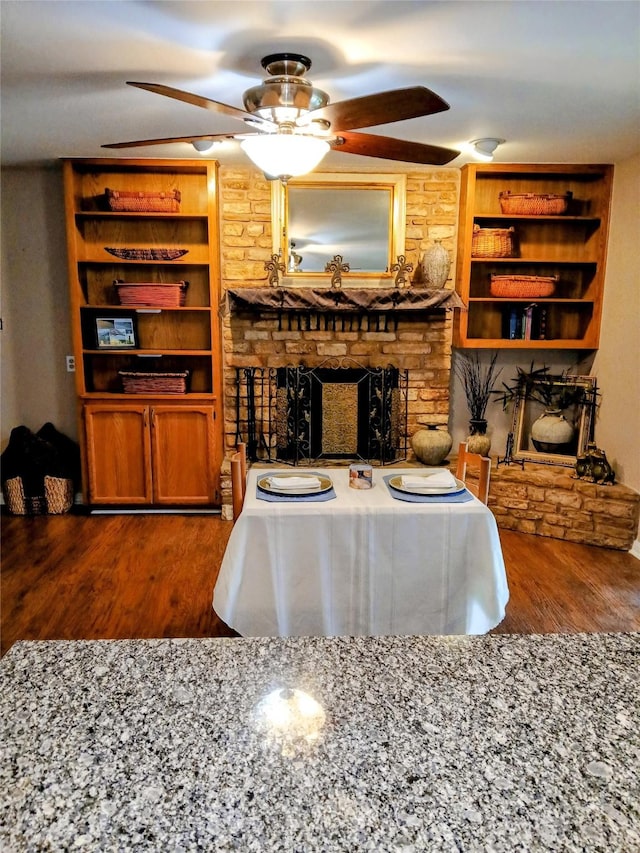 650 Sp Terry Rd, Belton, TX 76513 - living area with a large fireplace, a ceiling fan, dark wood-style flooring, and built in features