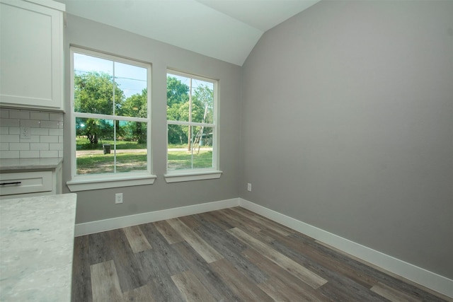 519 W James St, Wills Point, TX 75169 - unfurnished dining area with healthy amount of natural light, vaulted ceiling, dark wood-style flooring, and baseboards