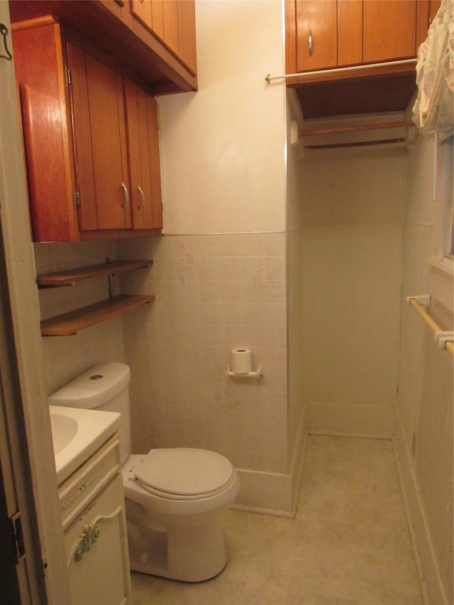 101 E Murray St, Denison, TX 75021 - bathroom featuring toilet, tile walls, tile patterned floors, wainscoting, and vanity
