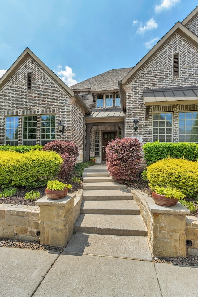 444 Francie Way, Allen, TX 75013 - view of exterior entry with a standing seam roof, roof with shingles, metal roof, and brick siding