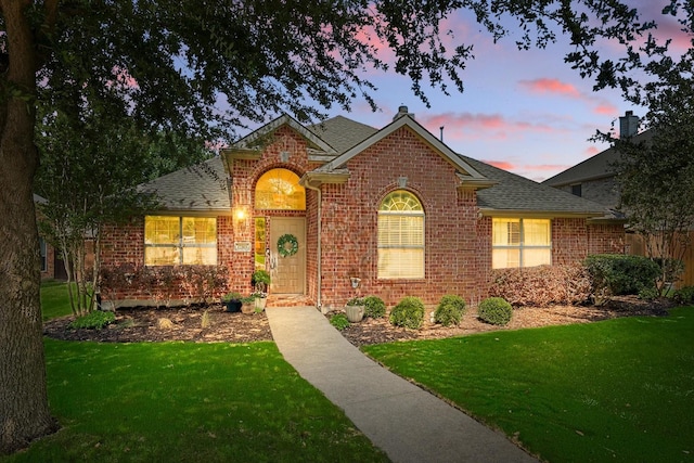 12303 Blue Ridge Dr, Frisco, TX 75033 - traditional-style house featuring brick siding, a yard, and a shingled roof