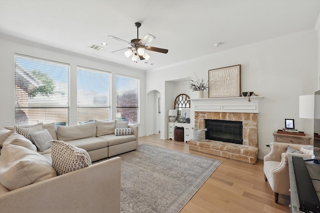 12303 Blue Ridge Dr, Frisco, TX 75033 - living room featuring ceiling fan, crown molding, arched walkways, healthy amount of natural light, and light wood finished floors