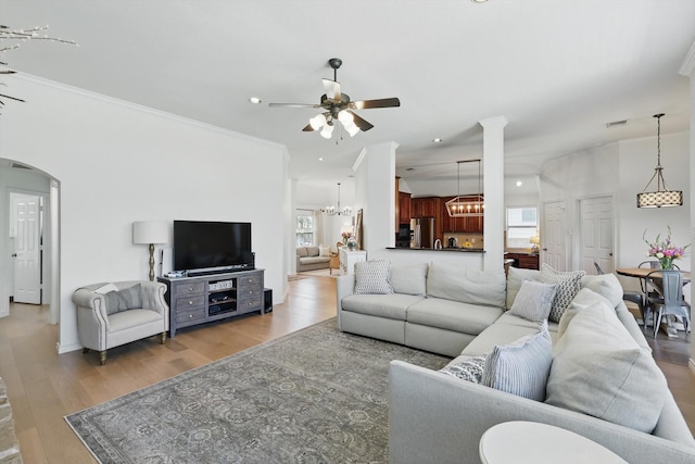 12303 Blue Ridge Dr, Frisco, TX 75033 - living room featuring ceiling fan, light wood finished floors, ornamental molding, a chandelier, and arched walkways