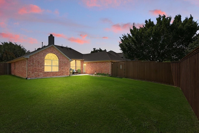 12303 Blue Ridge Dr, Frisco, TX 75033 - back of house at dusk with brick siding and a chimney