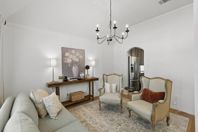 12303 Blue Ridge Dr, Frisco, TX 75033 - living room featuring arched walkways, a chandelier, wood finished floors, ornamental molding, and baseboards