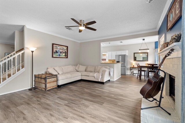 2804 Laurel Hill Dr, Flower Mound, TX 75028 - living room with light wood-type flooring, stairway, ceiling fan, crown molding, and a textured ceiling