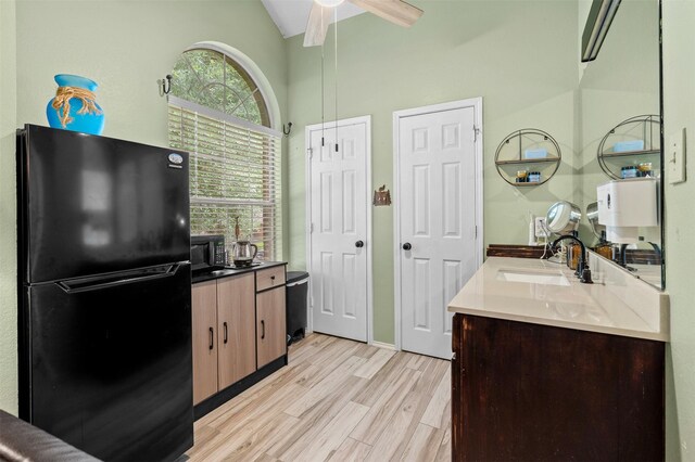 2804 Laurel Hill Dr, Flower Mound, TX 75028 - kitchen with black appliances, a sink, a ceiling fan, light wood-type flooring, and high vaulted ceiling