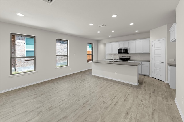 3105 Sedge Grass Dr, Melissa, TX 75454 - kitchen with stainless steel appliances, recessed lighting, dark countertops, light wood finished floors, and white cabinetry