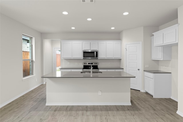 3105 Sedge Grass Dr, Melissa, TX 75454 - kitchen featuring stainless steel appliances, a center island with sink, white cabinetry, light wood-style flooring, and recessed lighting
