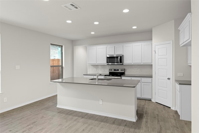 3105 Sedge Grass Dr, Melissa, TX 75454 - kitchen with appliances with stainless steel finishes, light wood-style flooring, a kitchen island with sink, decorative backsplash, and recessed lighting