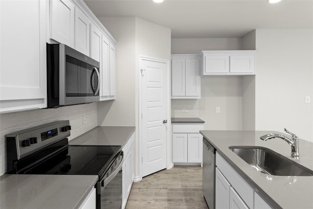 3105 Sedge Grass Dr, Melissa, TX 75454 - kitchen with appliances with stainless steel finishes, white cabinets, recessed lighting, decorative backsplash, and light wood-style floors