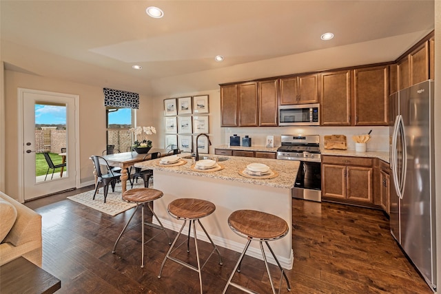 5308 Inwood Dr, Denton, TX 76207 - kitchen featuring stainless steel appliances, a sink, a kitchen breakfast bar, dark wood-type flooring, and recessed lighting