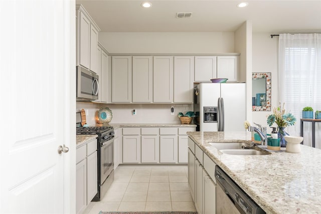 1909 Outpost Creek Ln, Aubrey, TX 76227 - kitchen with appliances with stainless steel finishes, a sink, light tile patterned floors, backsplash, and recessed lighting