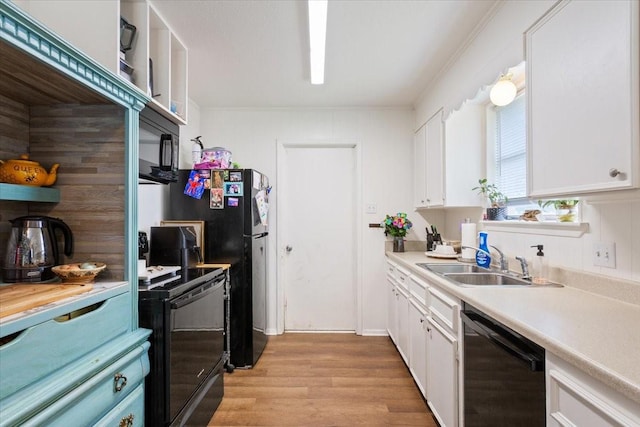 208 Alamosa Dr, Hewitt, TX 76643 - kitchen featuring black appliances, a sink, white cabinets, light wood-type flooring, and light countertops