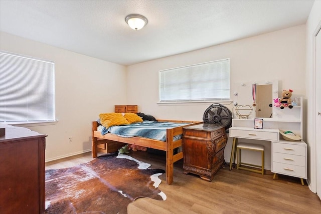 208 Alamosa Dr, Hewitt, TX 76643 - bedroom with wood finished floors and multiple windows