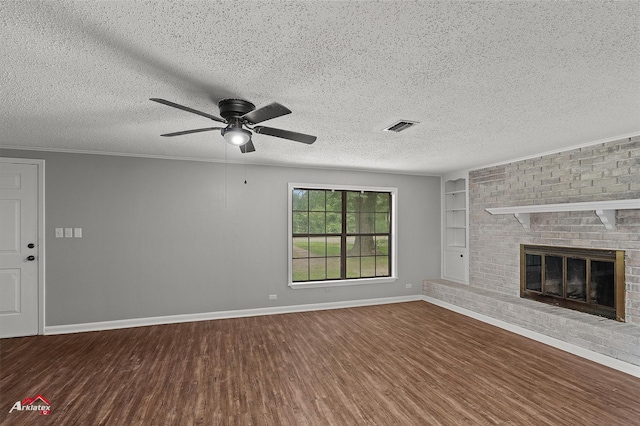 5630 Shreveport Blanchard Hwy, Shreveport, LA 71107 - unfurnished living room featuring wood finished floors, ceiling fan, baseboards, built in shelves, and a brick fireplace