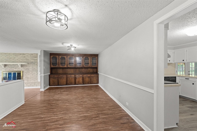 5630 Shreveport Blanchard Hwy, Shreveport, LA 71107 - unfurnished dining area featuring a textured ceiling, wood finished floors, a brick fireplace, and baseboards